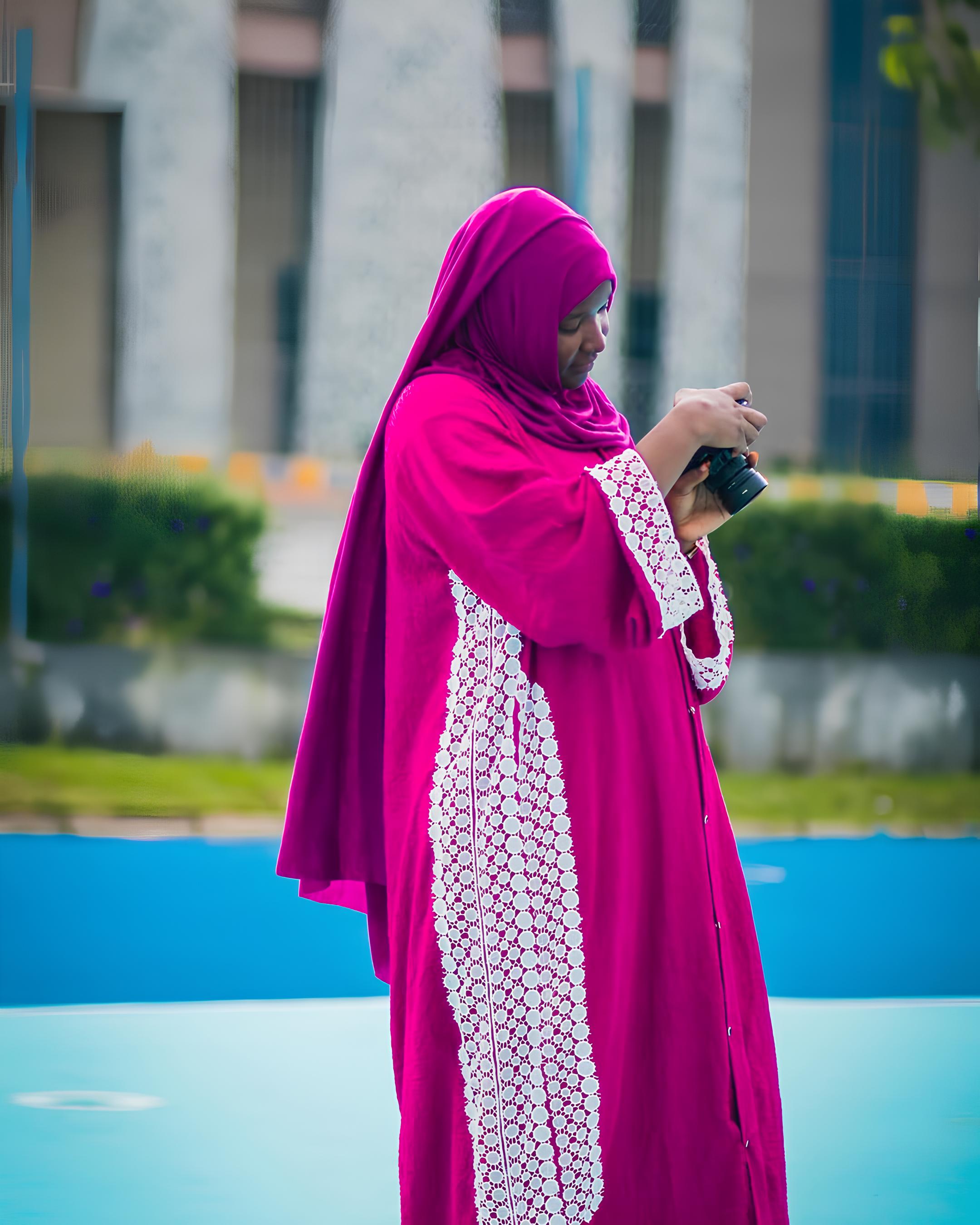 Iklima Babangida reviewing her camera settings outdoors